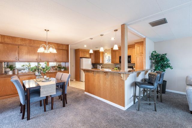 a dining room with a table chairs and a kitchen view