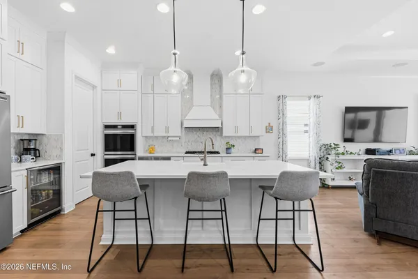a kitchen with stainless steel appliances kitchen island a table and chairs in it