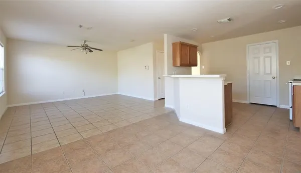 wooden floor in an empty room with a kitchen