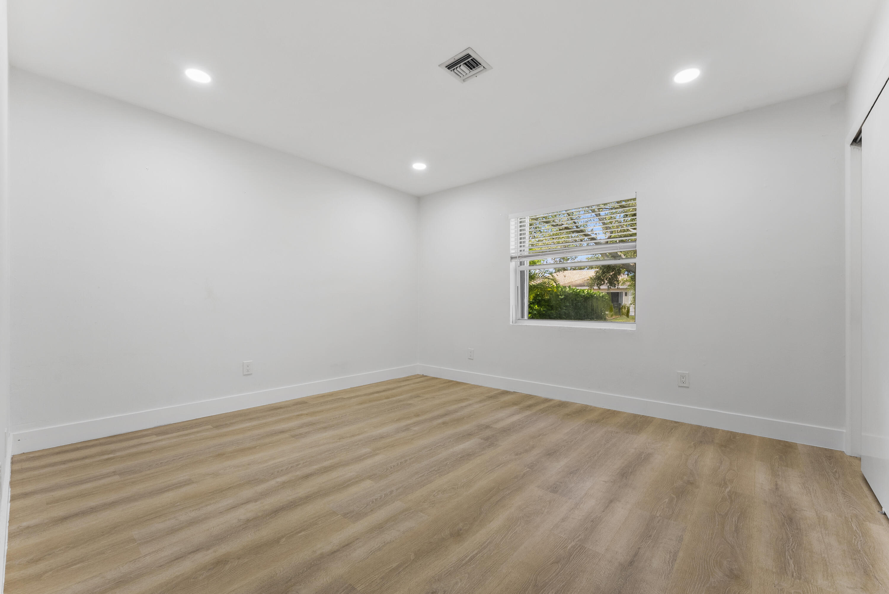 632 Allen Avenue, Unit 1 Delray Beach, FL 33483 - Photo 10 of 16 an empty room with wooden floor and windows