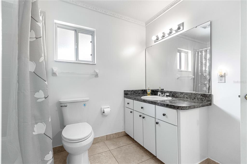 9840 Southwest 63rd Court Ocala, FL 34476 - Photo 15 of 49 a bathroom with a granite countertop toilet a sink and a mirror
