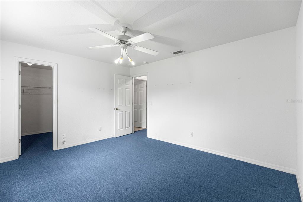 9840 Southwest 63rd Court Ocala, FL 34476 - Photo 19 of 49 an empty room with a ceiling fan and wooden floor