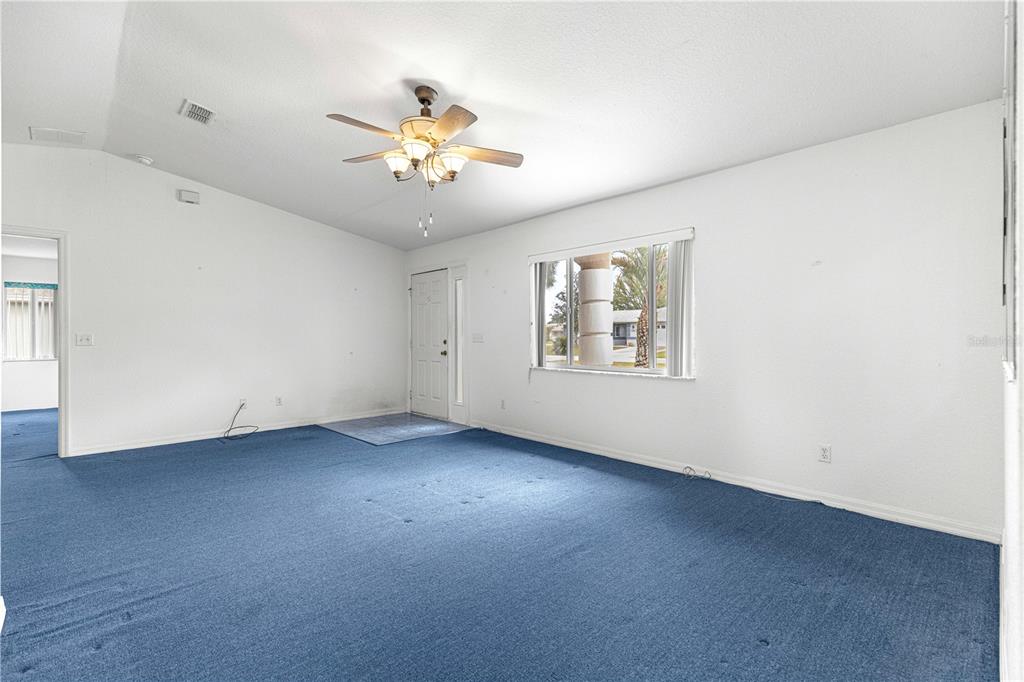 9840 Southwest 63rd Court Ocala, FL 34476 - Photo 20 of 49 an empty room with windows and chandelier fan
