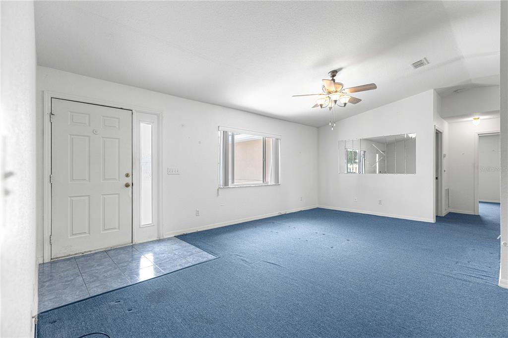 9840 Southwest 63rd Court Ocala, FL 34476 - Photo 2 of 49 an empty room with chandelier fan and windows