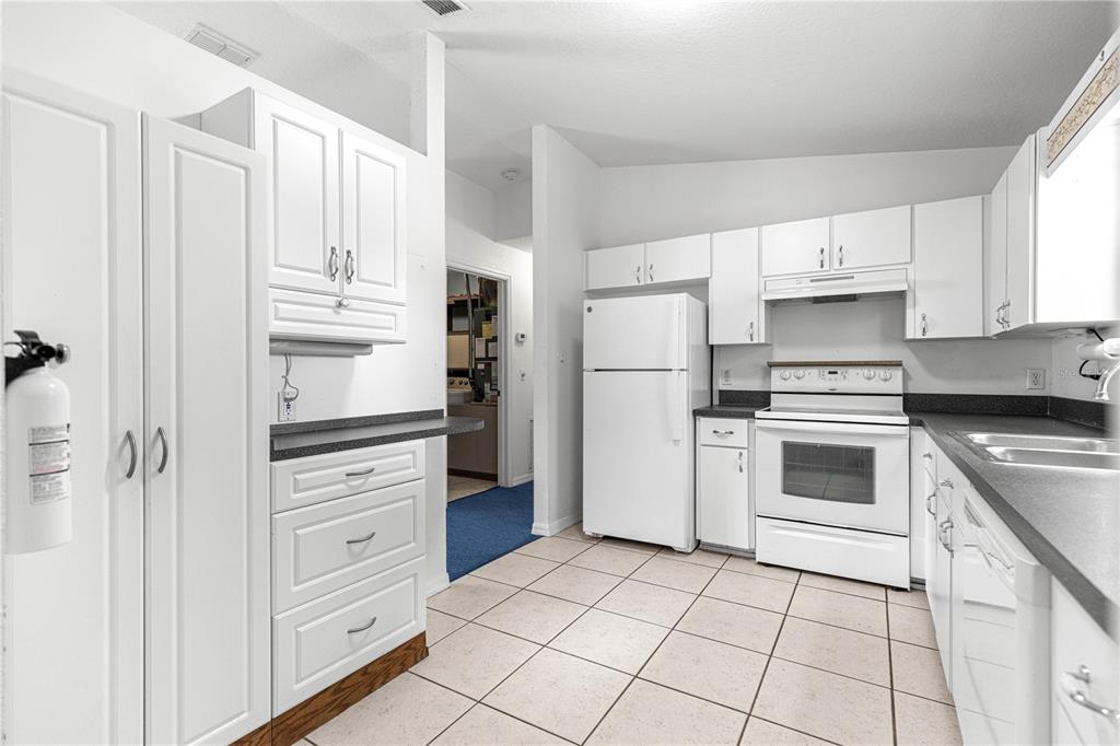 9840 Southwest 63rd Court Ocala, FL 34476 - Photo 26 of 49 a kitchen with white cabinets and white appliances