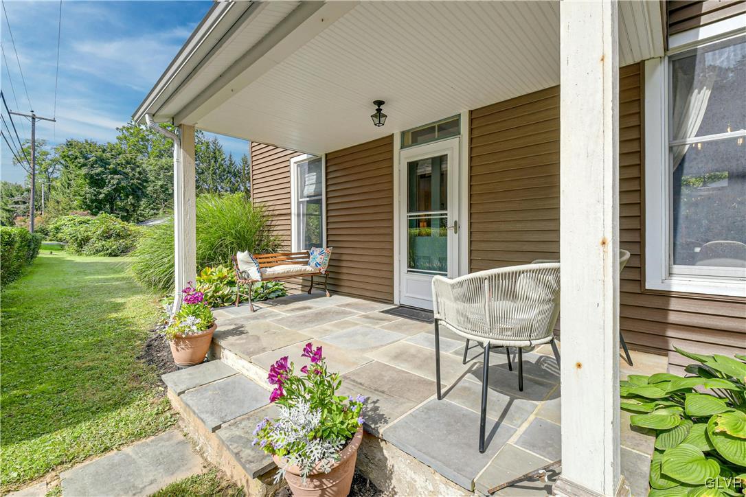 281 Old Furnace Road Riegelsville, PA 18077 - Photo 3 of 29 a porch with a table and chairs and potted plants