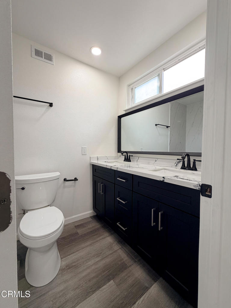 1430 Huntswood Way Oxnard, CA 93030 - Photo 7 of 14 a bathroom with a toilet sink double vanity and mirror