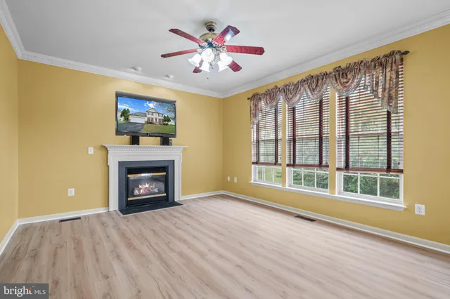a view of an empty room with a window and fireplace