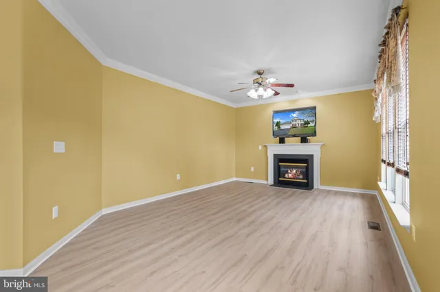 a view of an empty room with a fireplace and a window