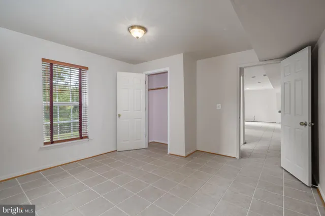 an empty room with windows and closet