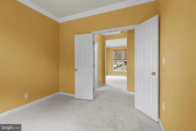 a view of an empty room with closet and a window
