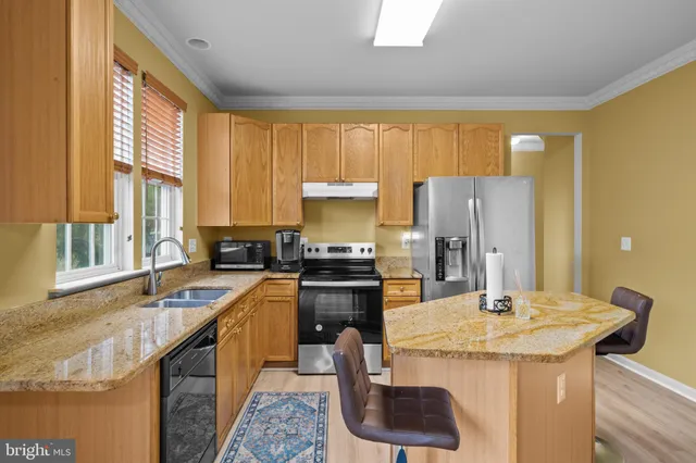 a kitchen with a sink a kitchen island and a refrigerator