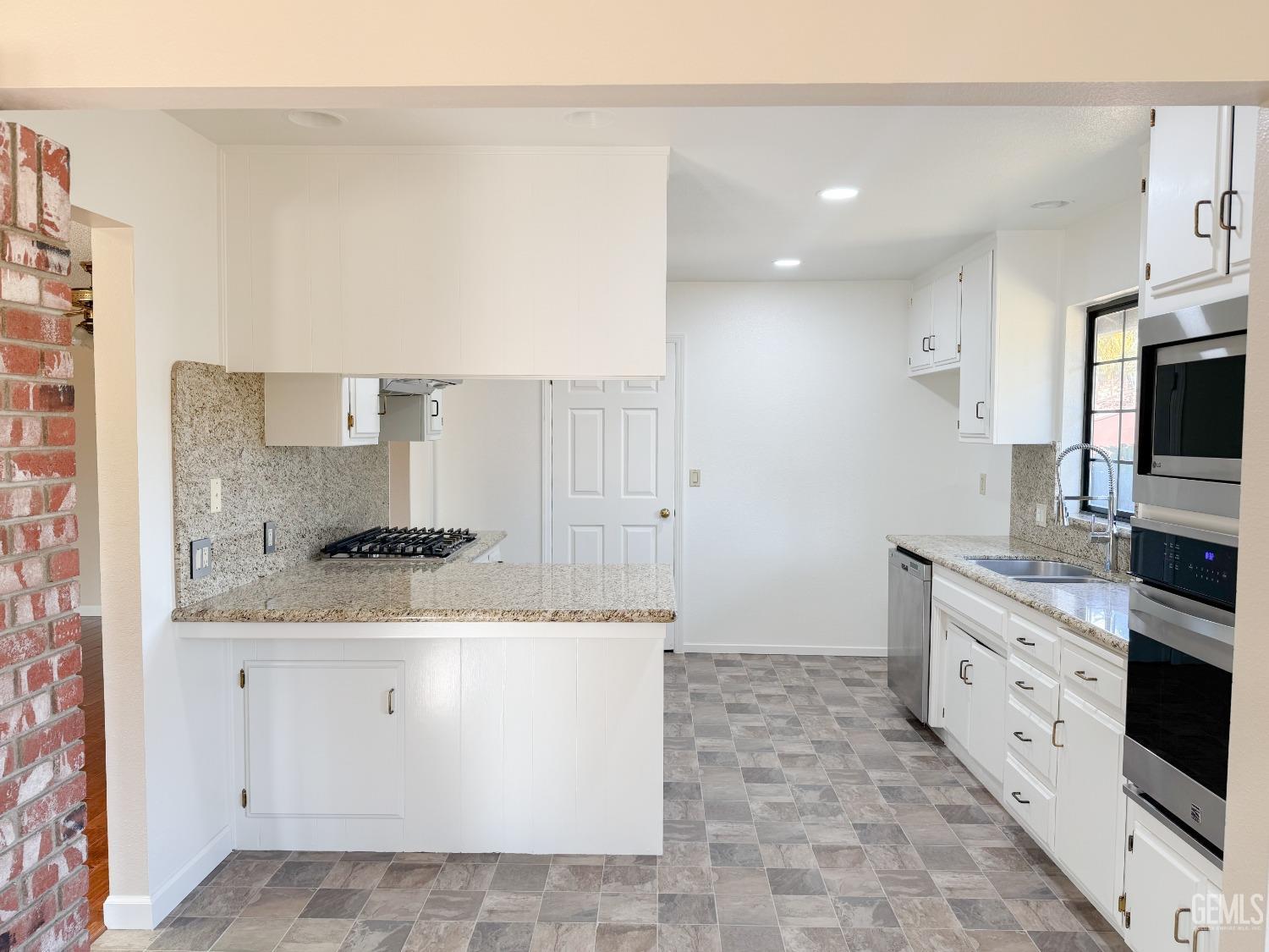 Undisclosed Address Bakersfield, CA 93307 - Photo 11 of 46 a kitchen with stainless steel appliances granite countertop a stove a sink and a microwave