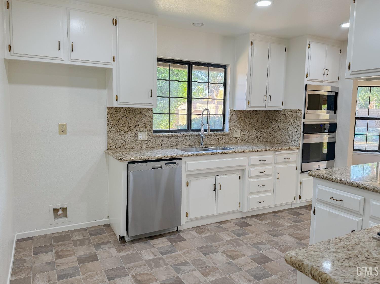 Undisclosed Address Bakersfield, CA 93307 - Photo 13 of 46 a kitchen with granite countertop white cabinets and stainless steel appliances