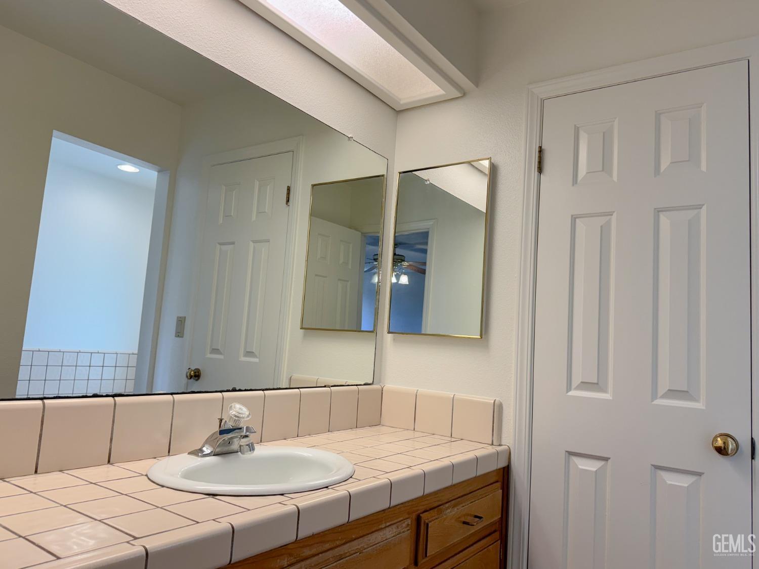 Undisclosed Address Bakersfield, CA 93307 - Photo 23 of 46 a bathroom with a sink and a mirror