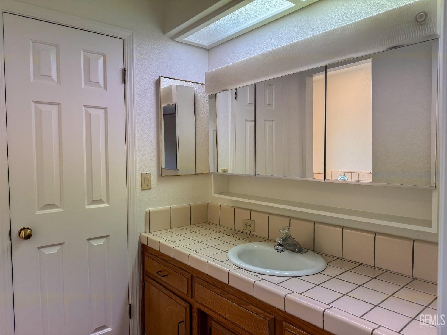Undisclosed Address Bakersfield, CA 93307 - Photo 25 of 46 a bathroom with a granite countertop sink and a mirror