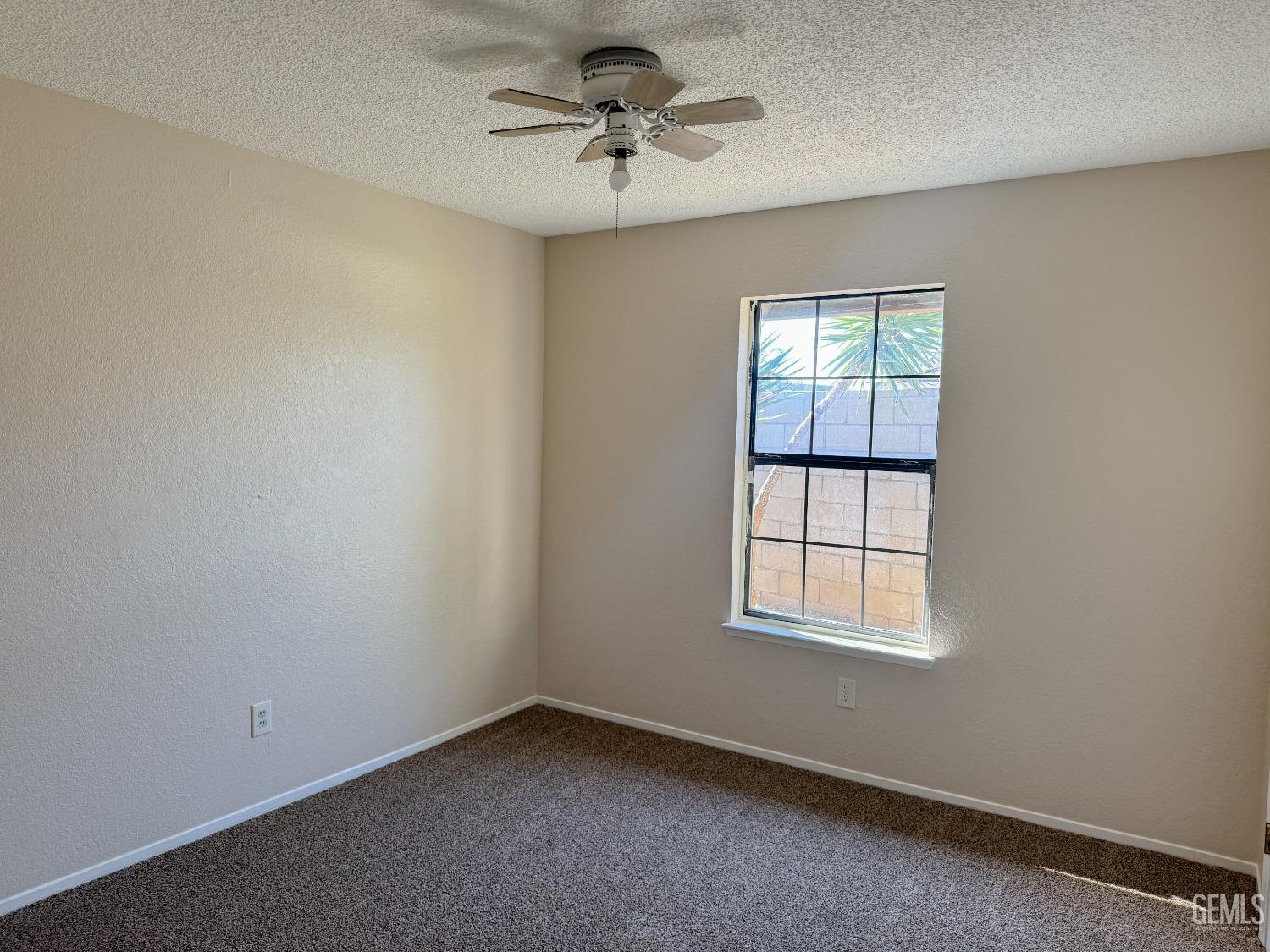 Undisclosed Address Bakersfield, CA 93307 - Photo 26 of 46 an empty room with windows and ceiling fan