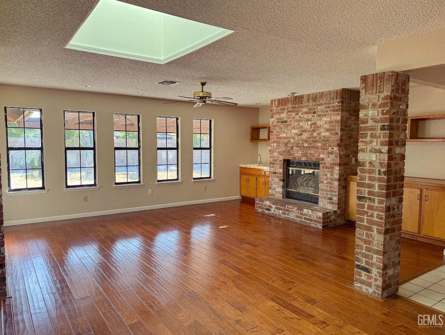 Undisclosed Address Bakersfield, CA 93307 - Photo 6 of 46 wooden floor in an empty room with a fireplace and wooden floor