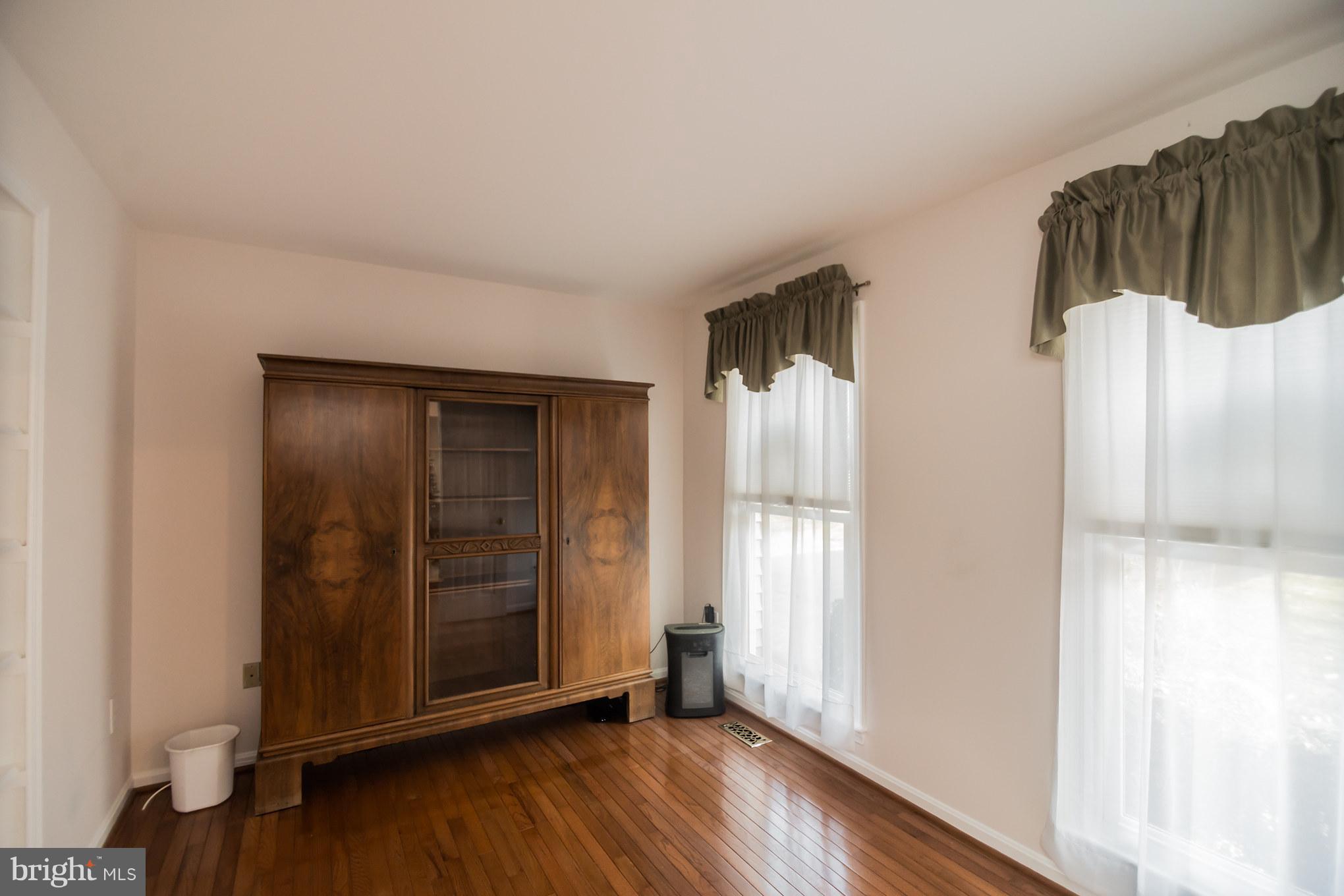 13016 Smoketown Road Woodbridge, VA 22192 - Photo 5 of 30 an empty room with wooden floor and windows