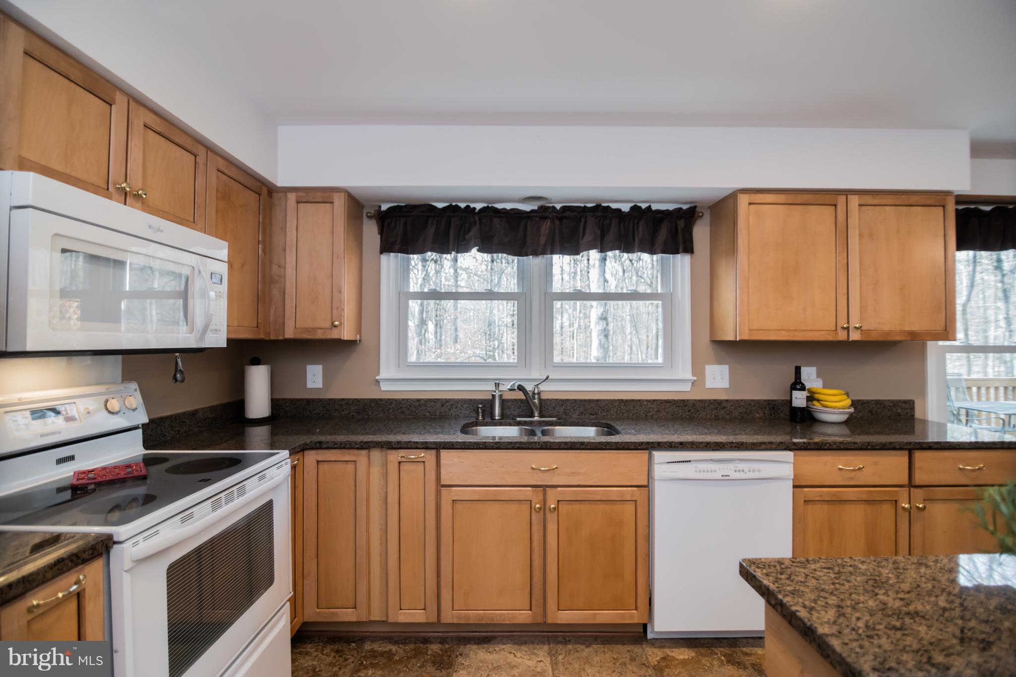 13016 Smoketown Road Woodbridge, VA 22192 - Photo 8 of 30 a kitchen with granite countertop a sink a stove and cabinets