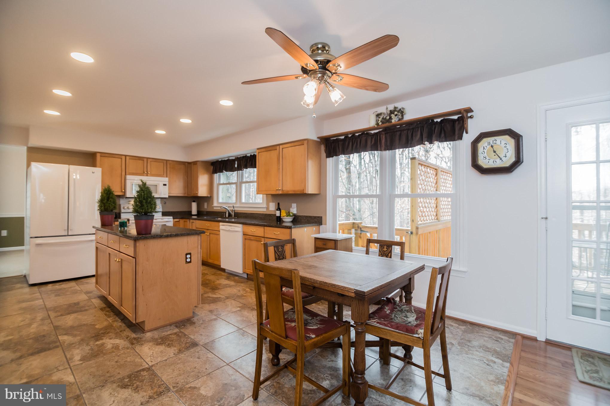 13016 Smoketown Road Woodbridge, VA 22192 - Photo 9 of 30 a kitchen with a table chairs and a refrigerator
