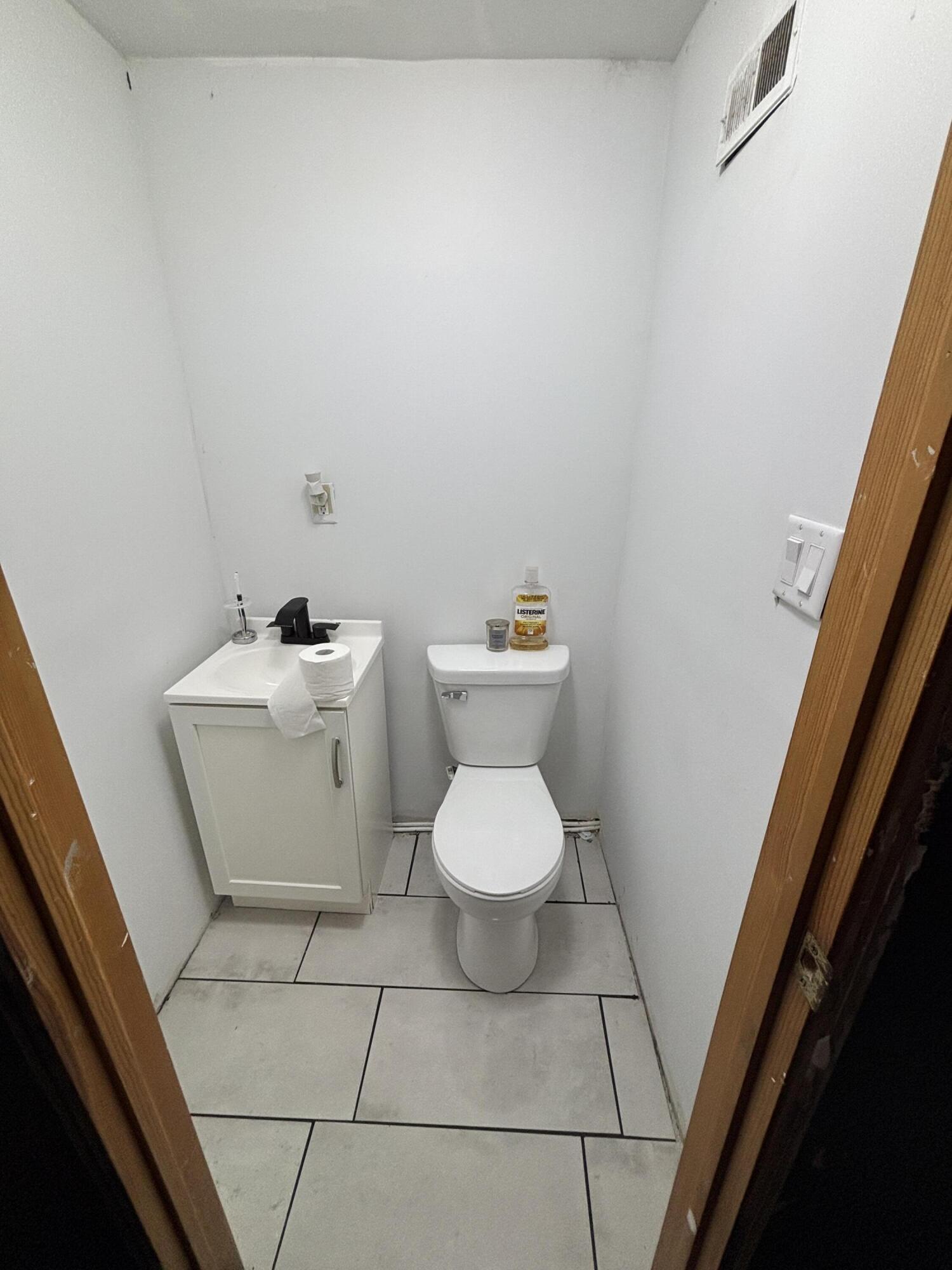 2154 Whitcomb Street Gary, IN 46404 - Photo 7 of 12 a white toilet sitting next to a bathroom sink