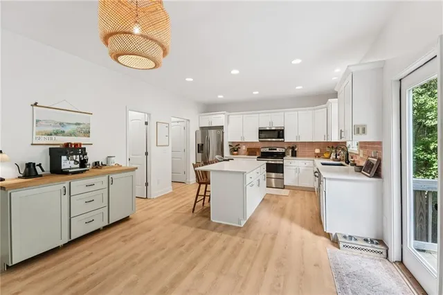 a kitchen with refrigerator a sink and white cabinets