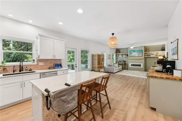 a kitchen with stainless steel appliances granite countertop a stove a sink a microwave a dining table and chairs