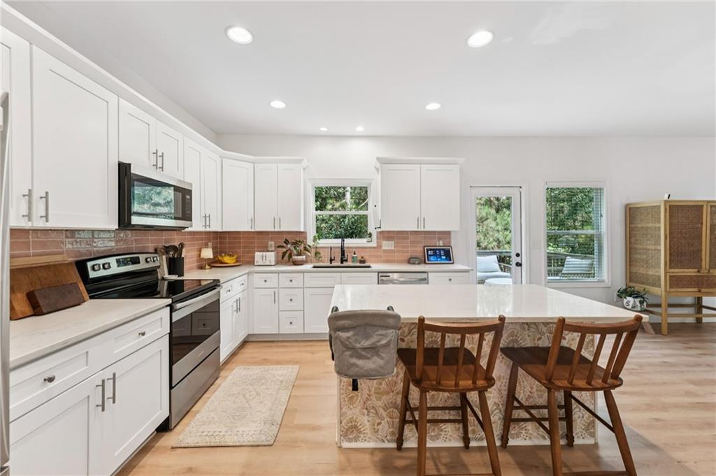 621 Stonehurst Lane Canton, GA 30114 - Photo 18 of 62 a kitchen with stainless steel appliances granite countertop a stove a sink a microwave a dining table and chairs