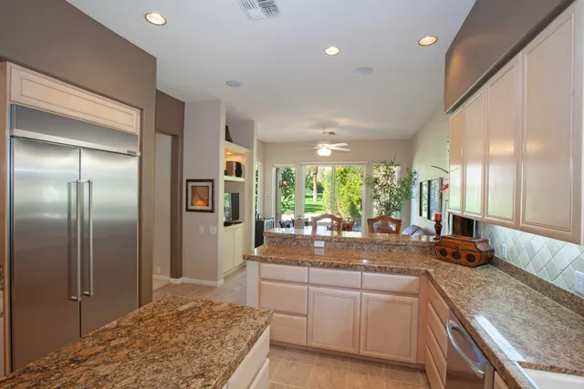 a kitchen with granite countertop a refrigerator and a sink