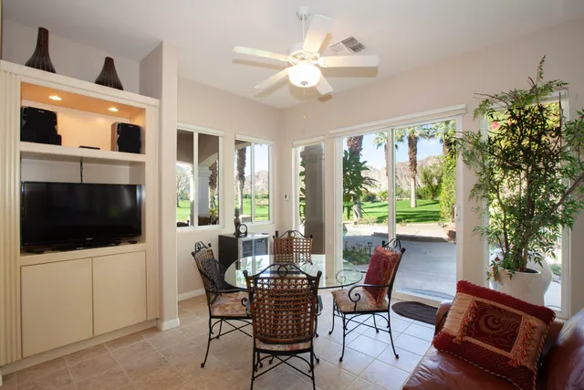 a dining room with furniture a flat screen tv and a large window