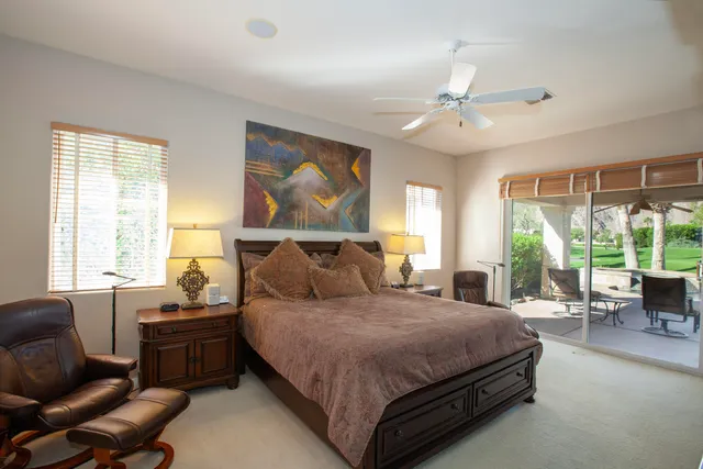 a bedroom with a large bed couch and a large window