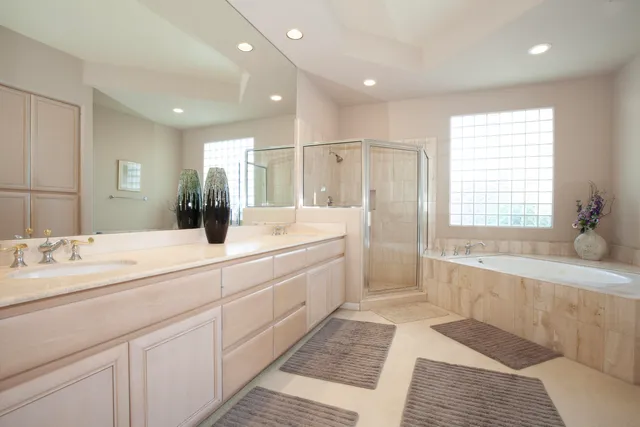 a spacious bathroom with sinks mirror and a bathtub