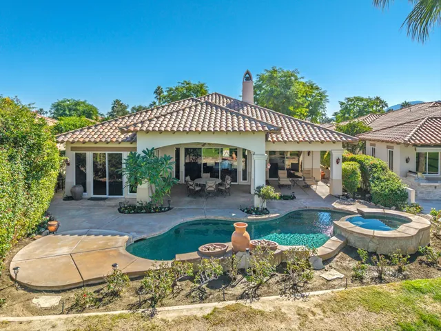 a view of a house with backyard swimming pool and sitting area