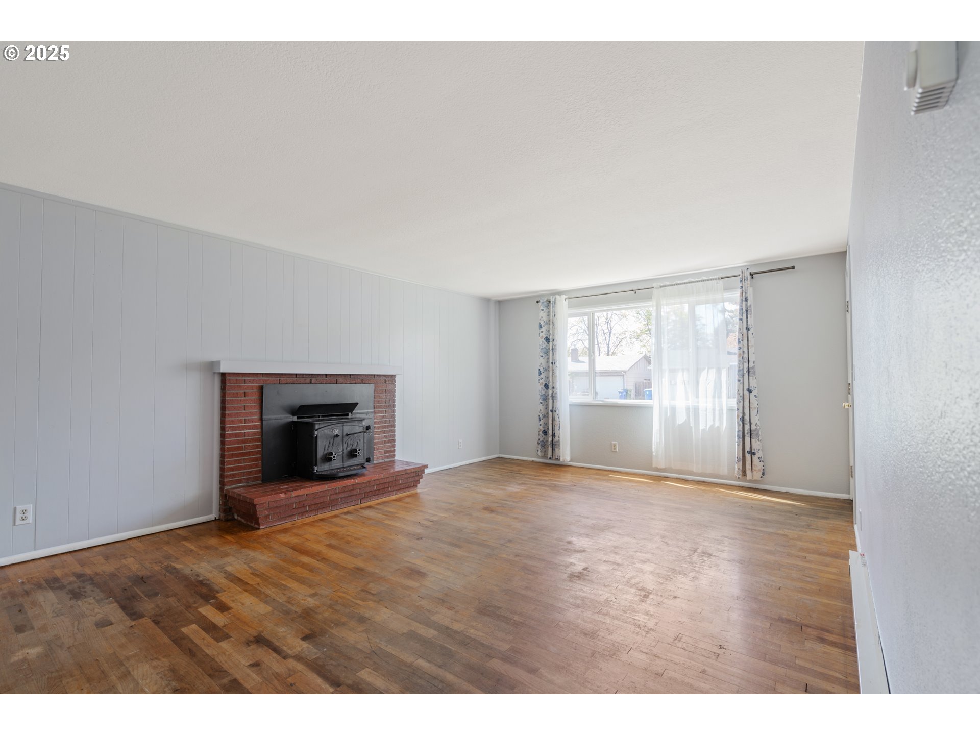1855 Alderwood Street Eugene, OR 97404 - Photo 3 of 31 a view of an empty room with a window and wooden floor
