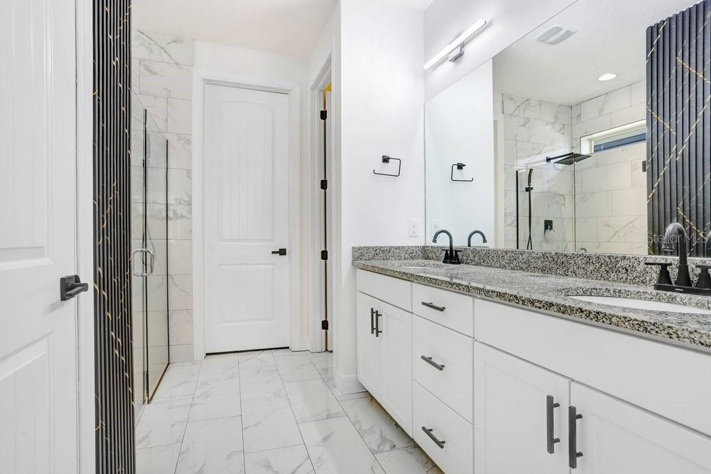 11677 Brighton Knoll Loop Riverview, FL 33579 - Photo 14 of 30 a bathroom with a granite countertop sink two mirror and shower