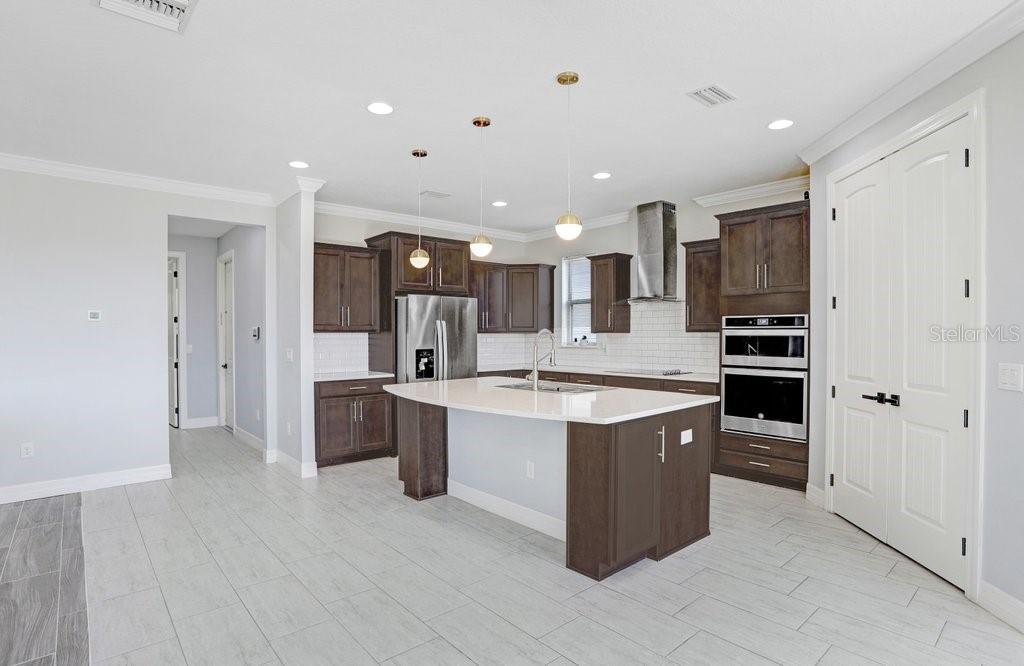 11677 Brighton Knoll Loop Riverview, FL 33579 - Photo 21 of 30 a large kitchen with a large counter top a sink stainless steel appliances and cabinets