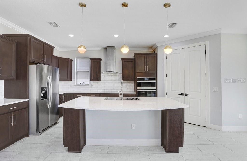 11677 Brighton Knoll Loop Riverview, FL 33579 - Photo 22 of 30 a large kitchen with a large counter top stainless steel appliances and cabinets