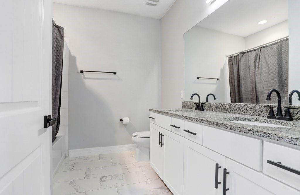 11677 Brighton Knoll Loop Riverview, FL 33579 - Photo 10 of 30 a bathroom with a granite countertop sink and a mirror