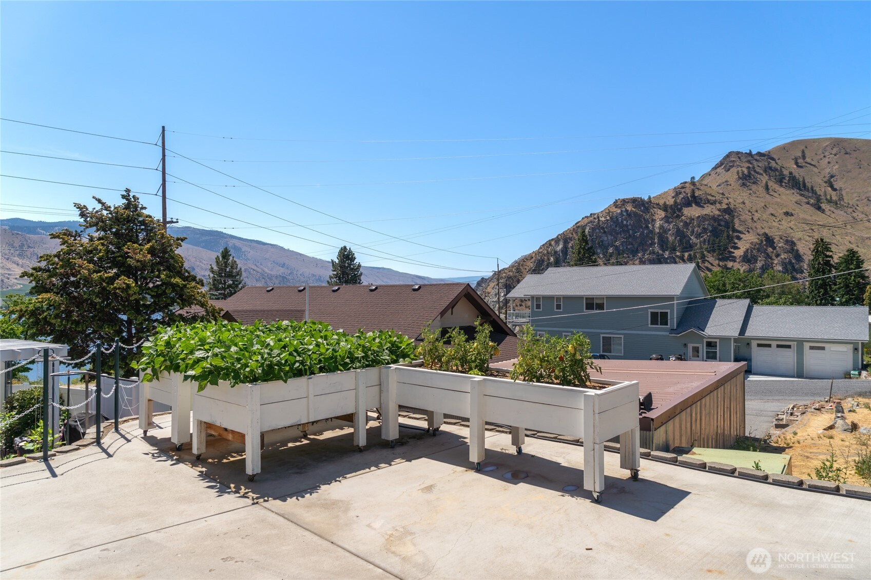 2548 Entiat Way Entiat, WA 98822 - Photo 30 of 40 a roof deck with table and chairs potted plants and a large tree