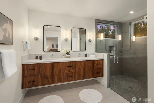 a bathroom with a double vanity sink mirror and shower