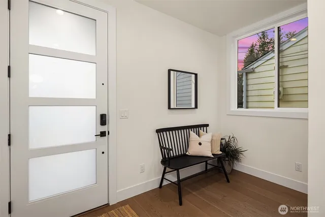 a view of a room with a bench wooden floor and windows