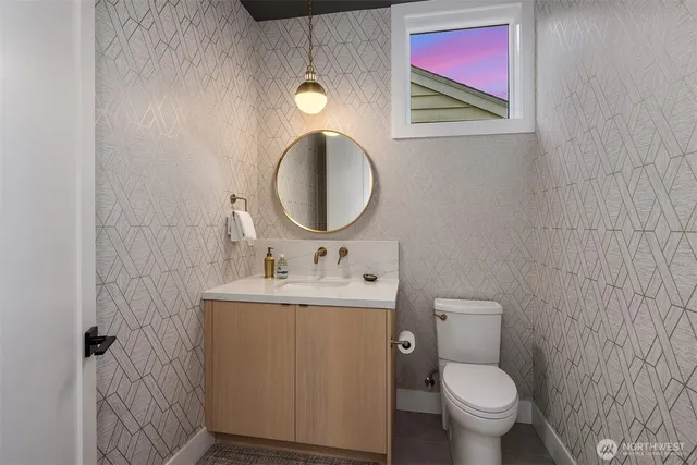 a bathroom with a toilet sink vanity and mirror