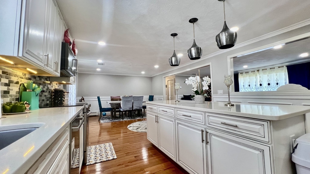 5 Flintlocke Road Franklin, MA 02038 - Photo 4 of 34 a large kitchen with stainless steel appliances a large center island a stove a sink a couch and a dining table with garden view