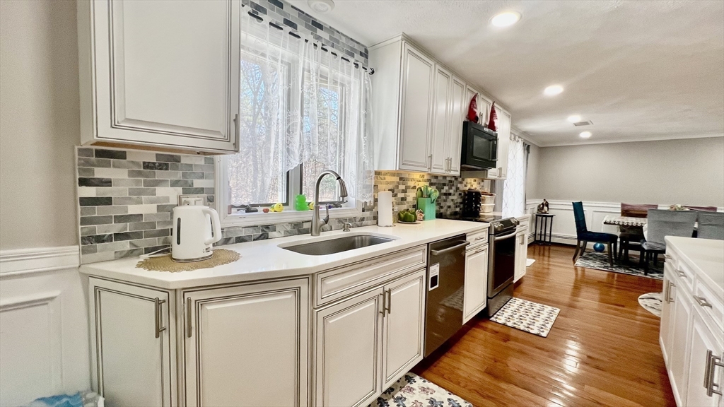 5 Flintlocke Road Franklin, MA 02038 - Photo 5 of 34 a kitchen with stainless steel appliances granite countertop a sink stove and cabinets