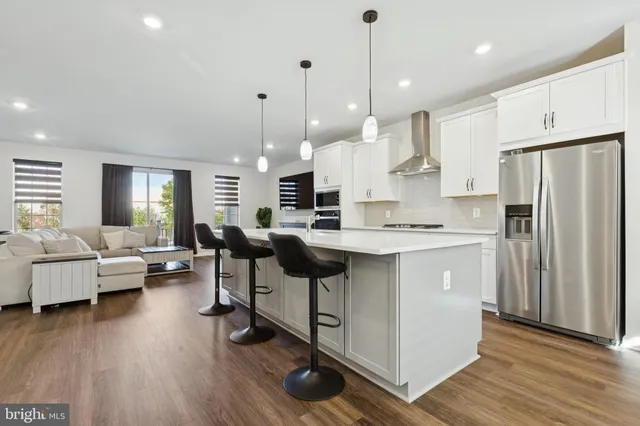 a living room with furniture a fireplace a flat screen tv and kitchen view