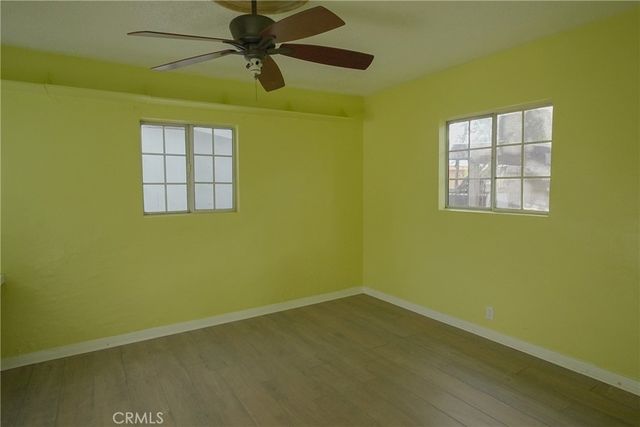 an empty room with windows and fan