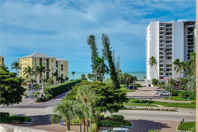 a living room with furniture a ceiling fan and a large window