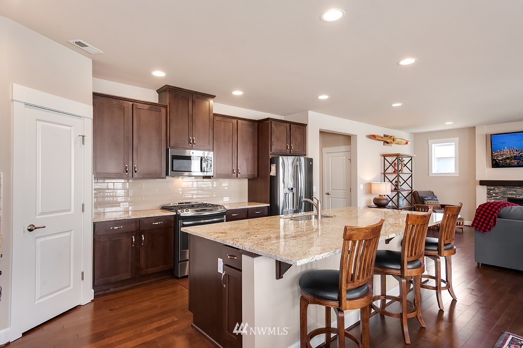 6100 Southeast 2nd Street Renton, WA 98059 - Photo 8 of 24 a kitchen with stainless steel appliances granite countertop a table chairs sink refrigerator and cabinets