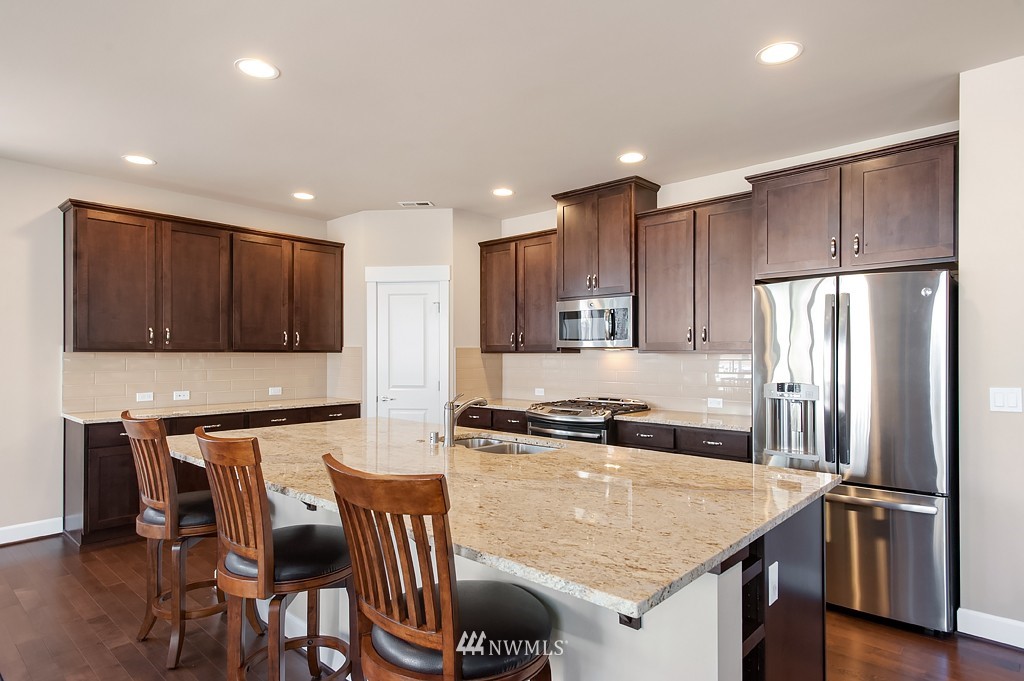 6100 Southeast 2nd Street Renton, WA 98059 - Photo 9 of 24 a kitchen with stainless steel appliances granite countertop a table chairs sink refrigerator and microwave